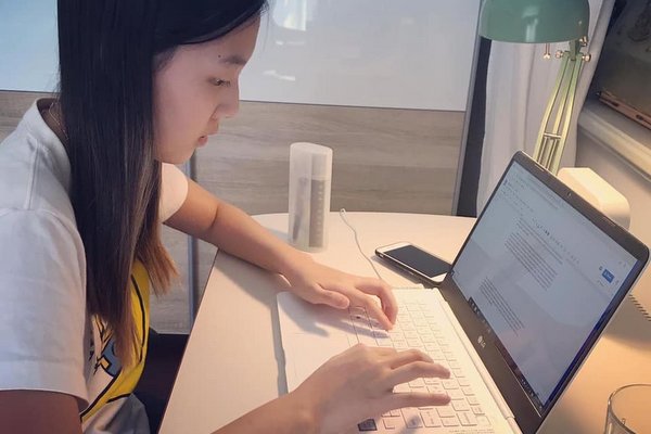 Young girl sitting in front of a laptop distance learning at Wroclaw International School